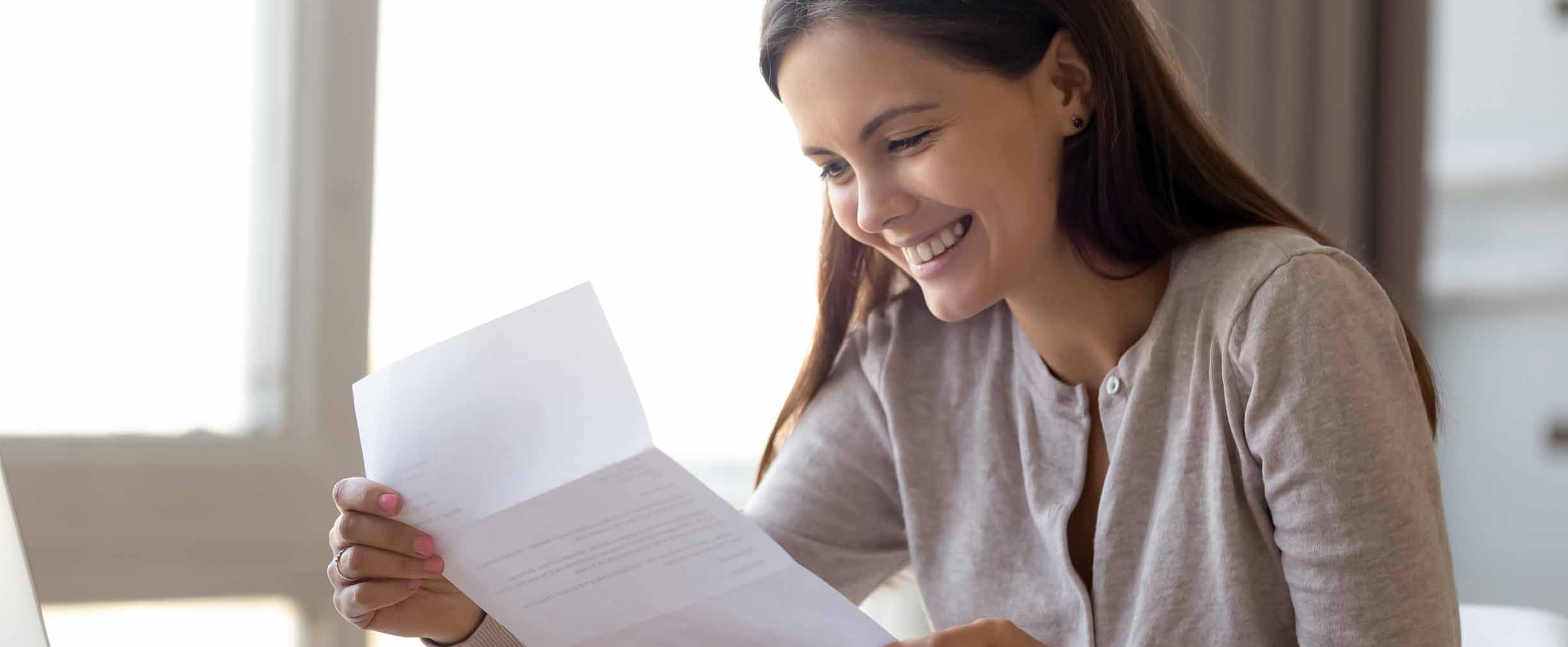 woman holding paper reading results