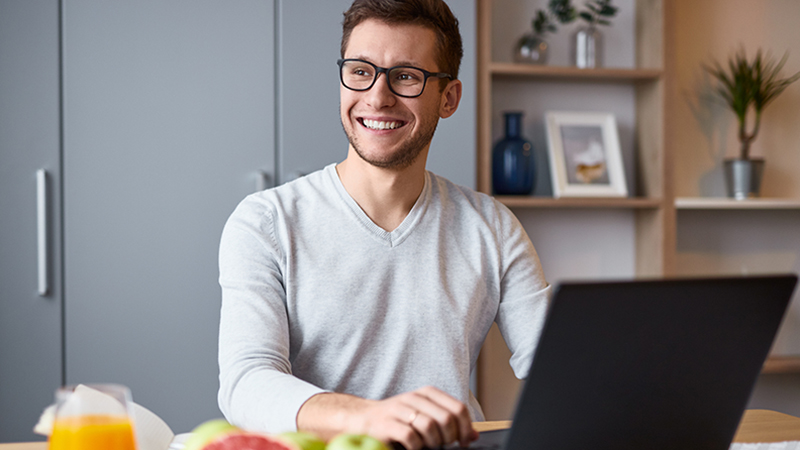 Man in front of laptop smiling