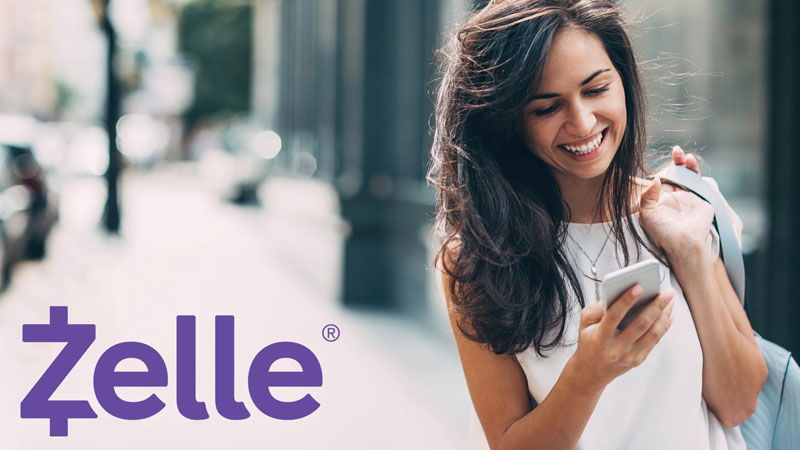 mujer usando Zelle en un teléfono móvil para enviar dinero