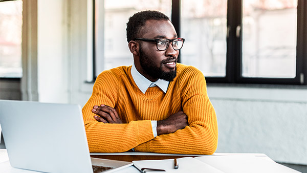 hombre afroamericano con un suéter amarillo en la oficina
