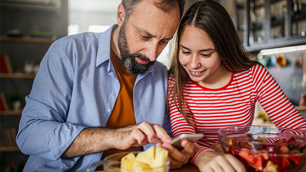 father and daughter preparing a meal in the kitchen