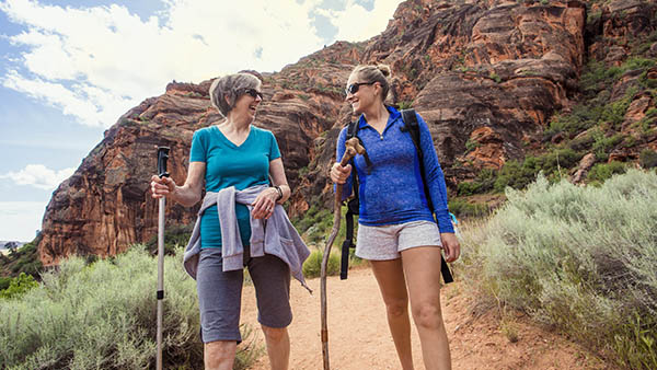 two women hiking through a canyon