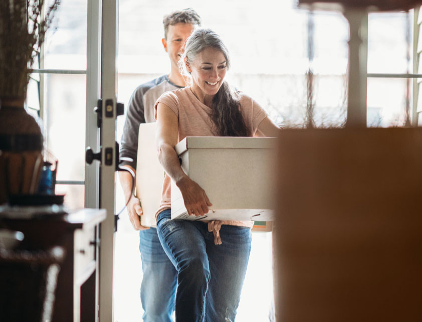 Couple moving boxes into home