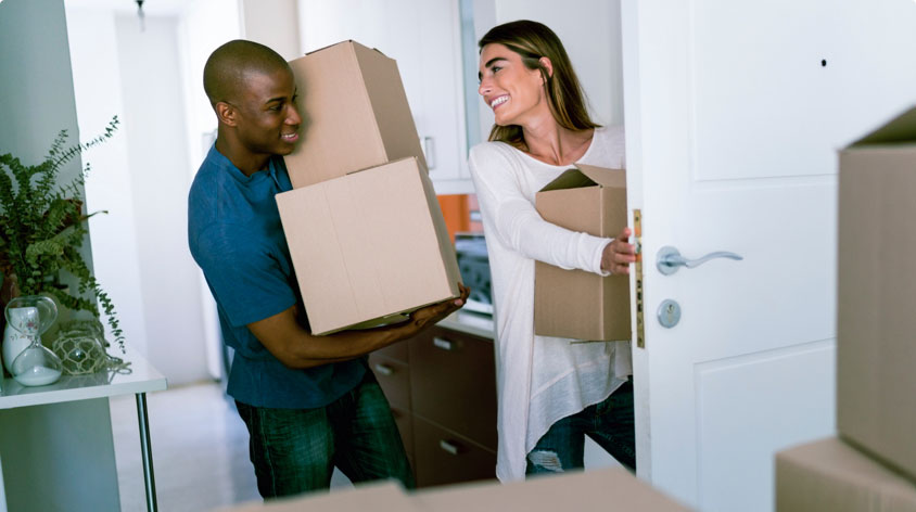 Couple moving boxes into home