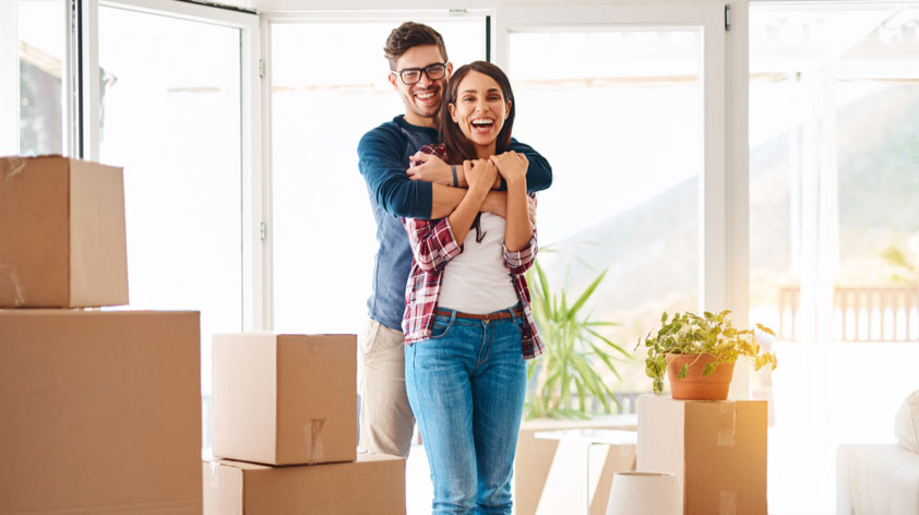 Pareja abrazada y con entusiasmo por su casa nueva