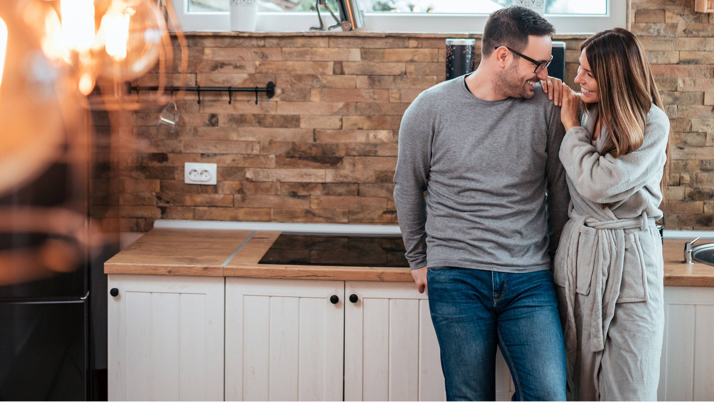 Couple looking lovingly at each other at kitchen sink