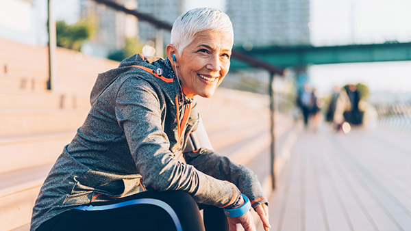 female senior sitting on a bench after a run
