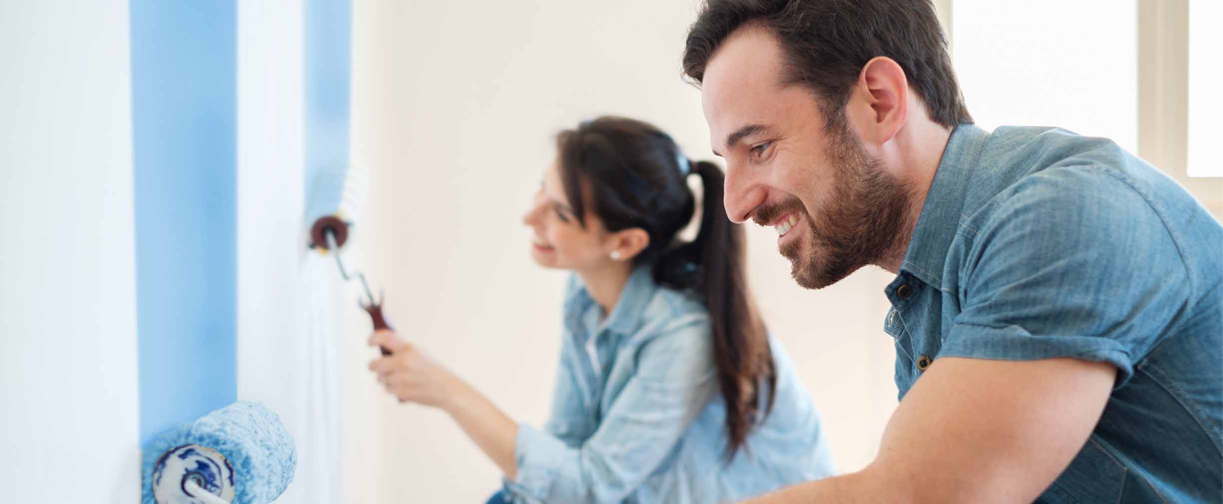 pareja joven pintando las paredes de su casa