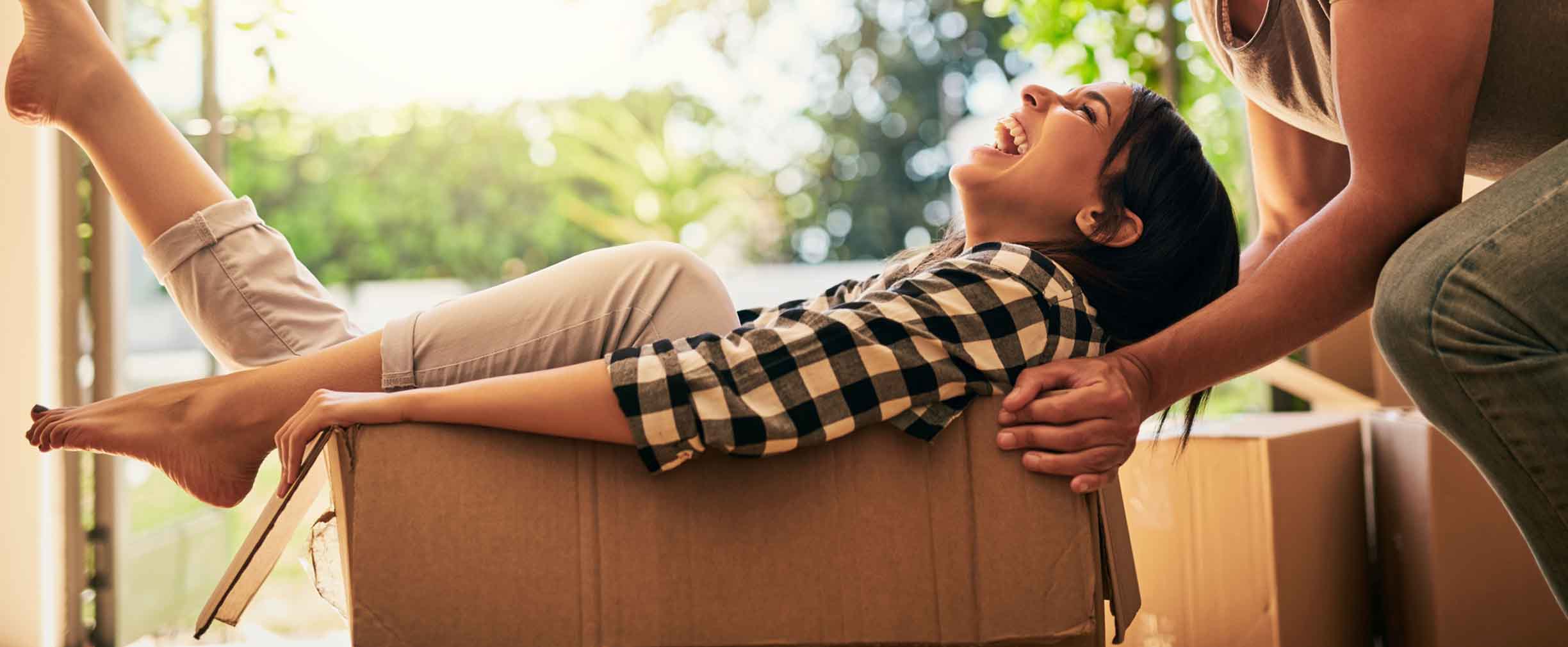 una pareja joven feliz desempacando cajas en su nueva casa