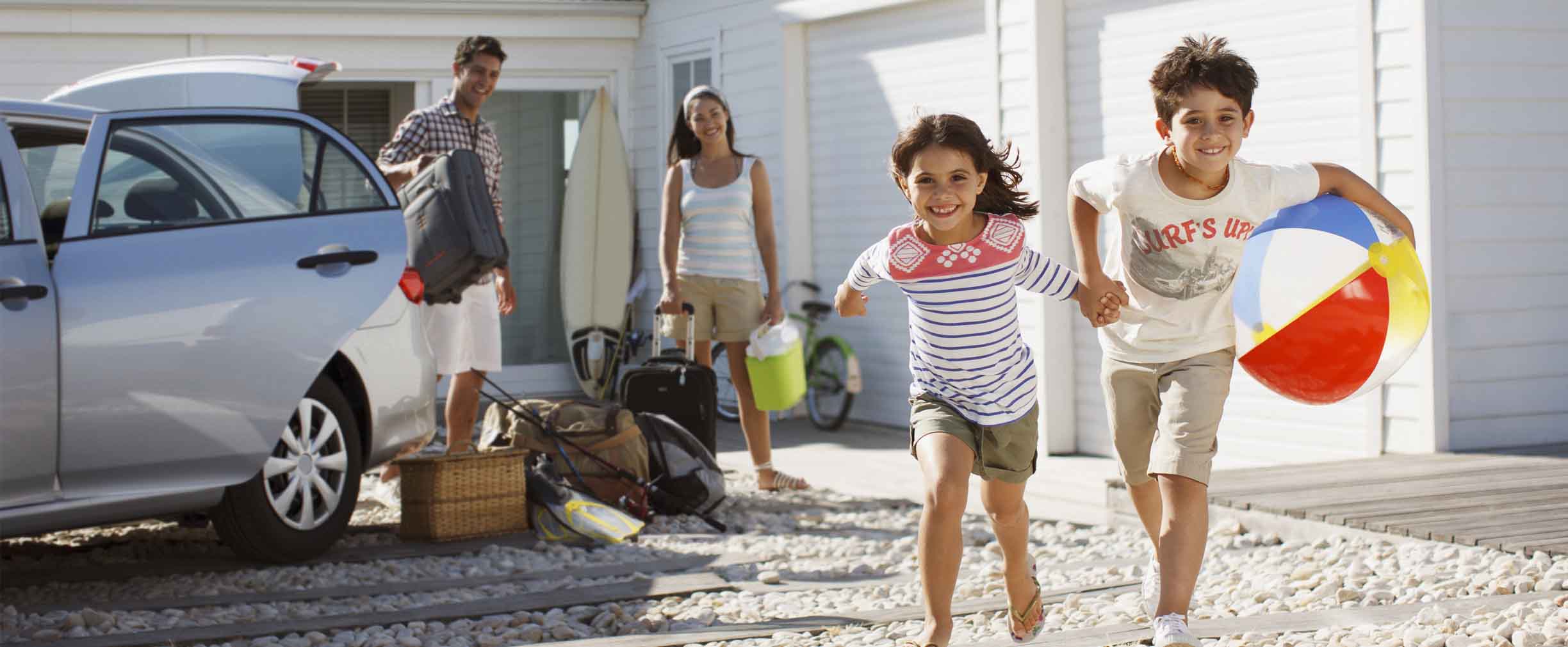 familia joven saliendo del auto en su vivienda  sobre la playa