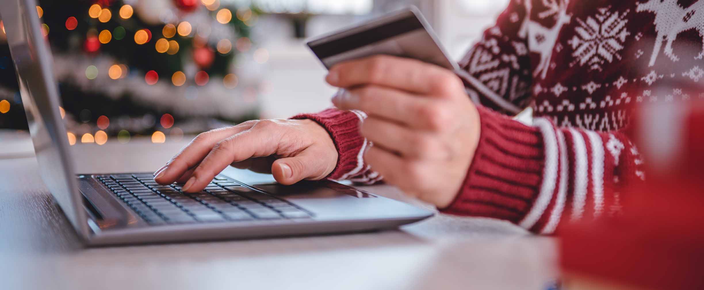 mujer con tarjeta de crédito en la mano comprando por Internet durante las fiestas