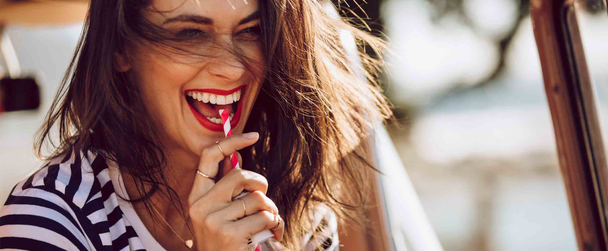 una mujer feliz tomando una gaseosa