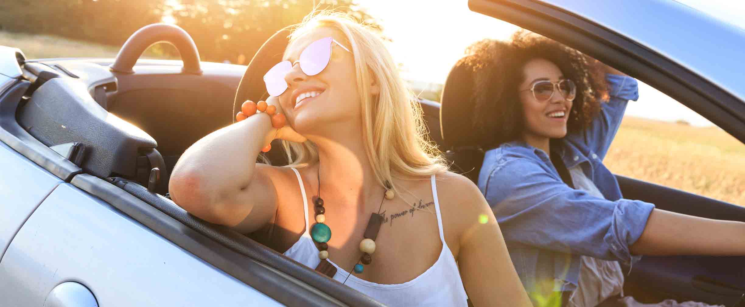 dos muchachas paseando en un auto