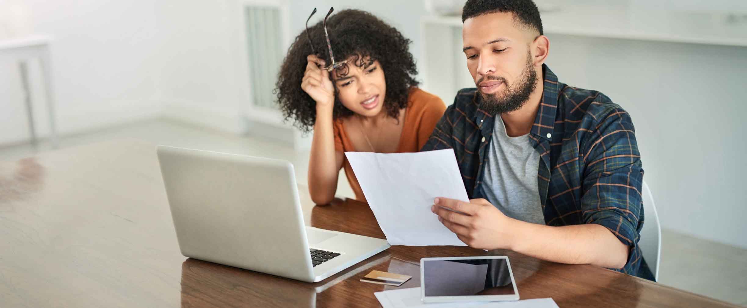 Toma de una pareja joven que se ve estresada mientras repasa sus finanzas en casa