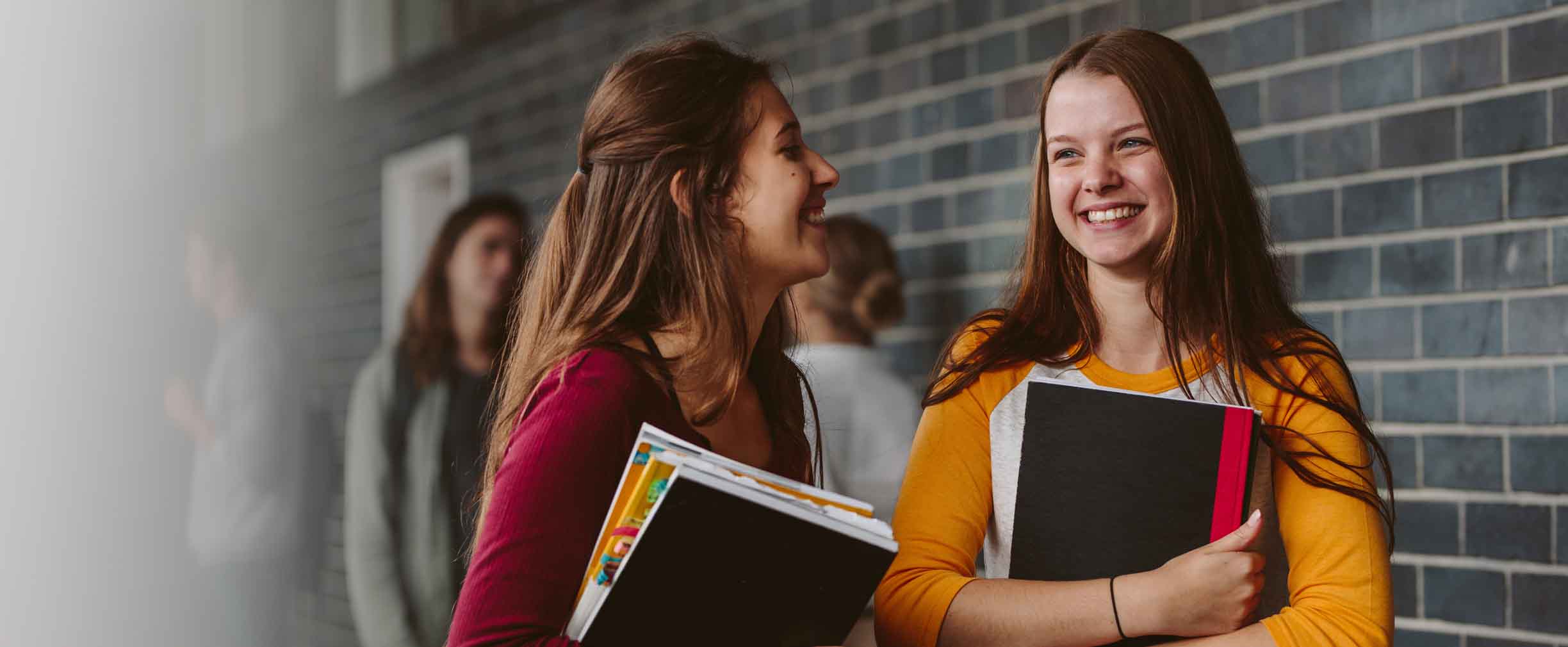 two female students holding books