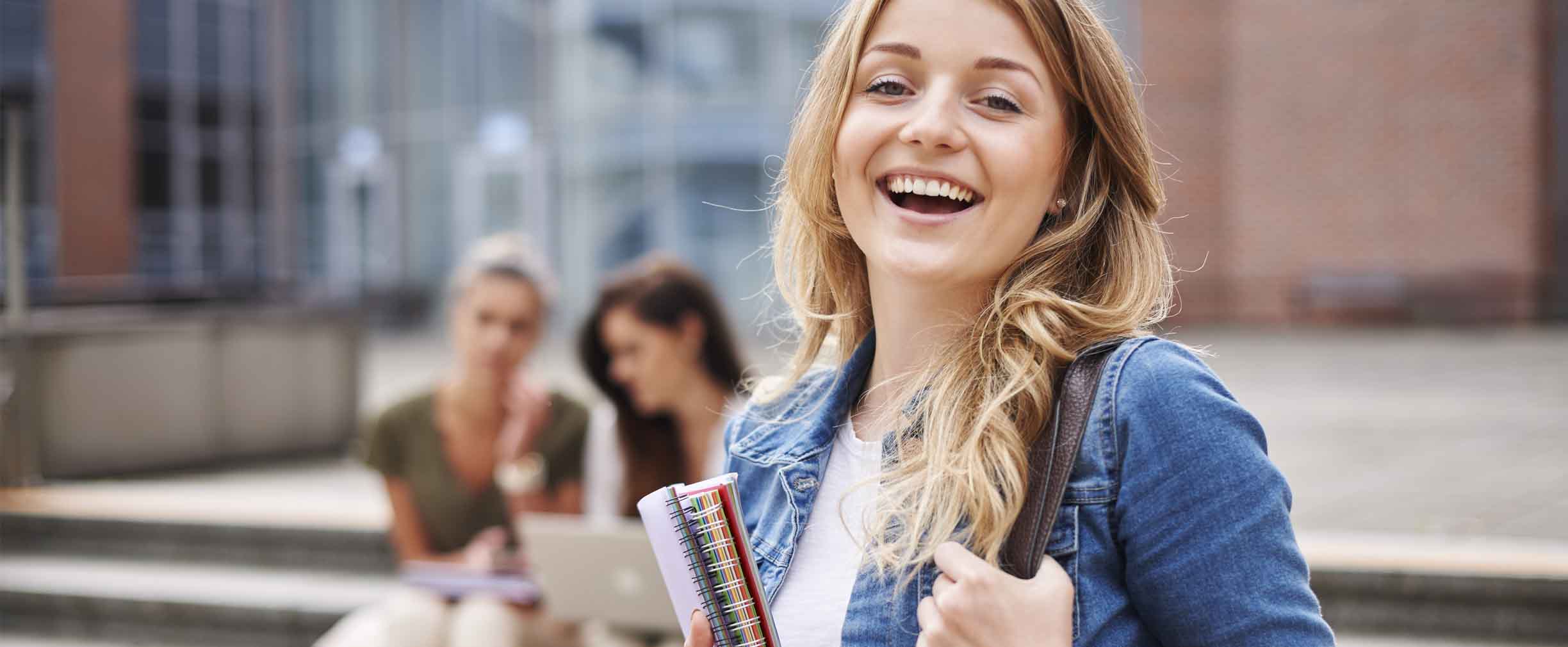 female student smiling holding books