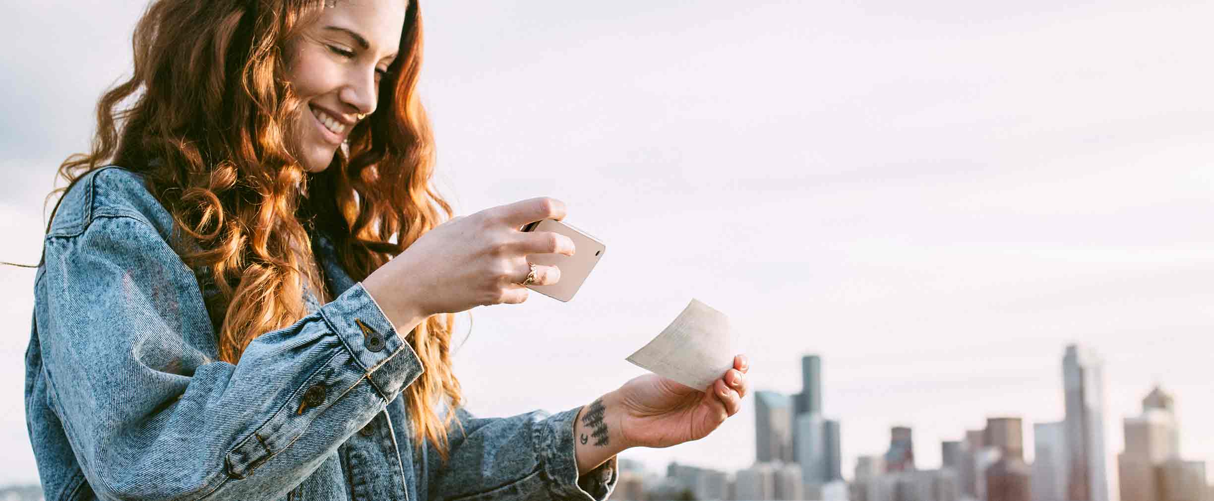 woman using mobile banking to deposit a check with her smartphone