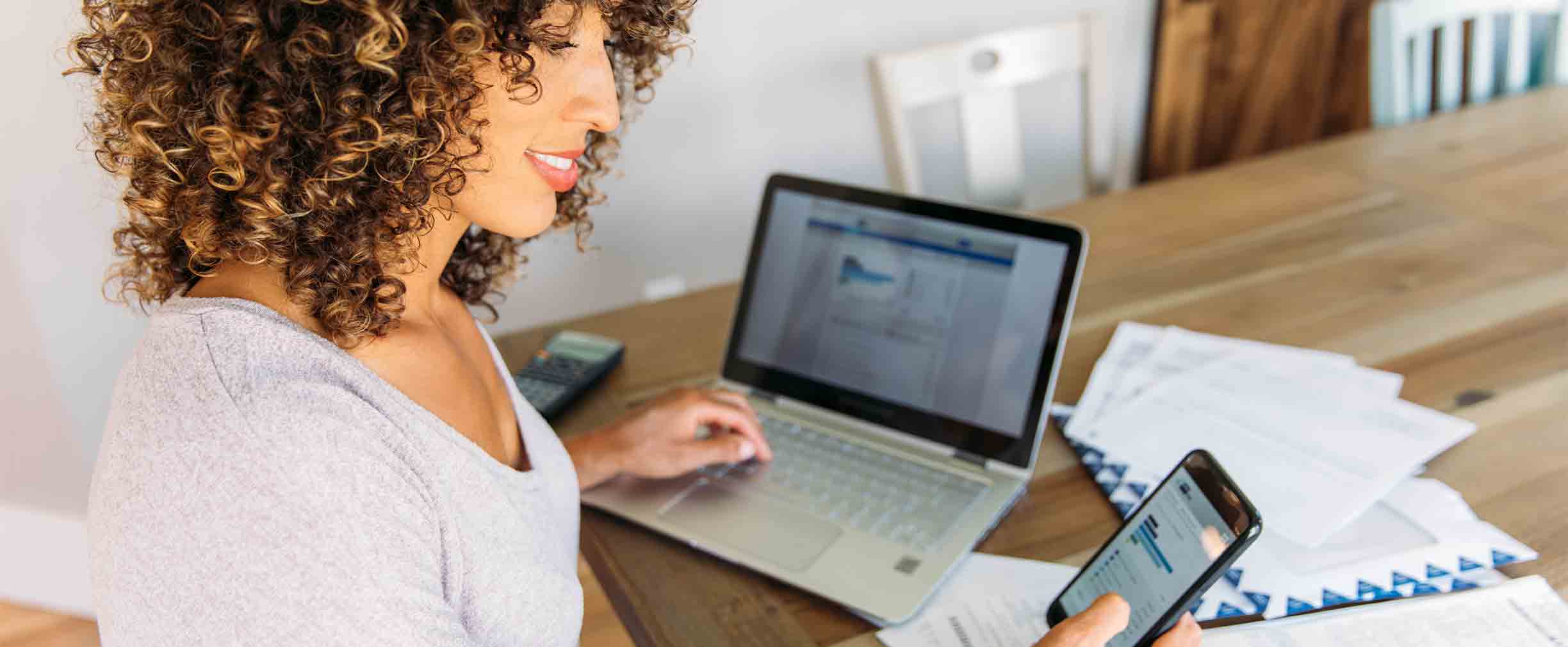 Foto de banco de imágenes: mujer haciendo finanzas en casa con teléfono inteligente