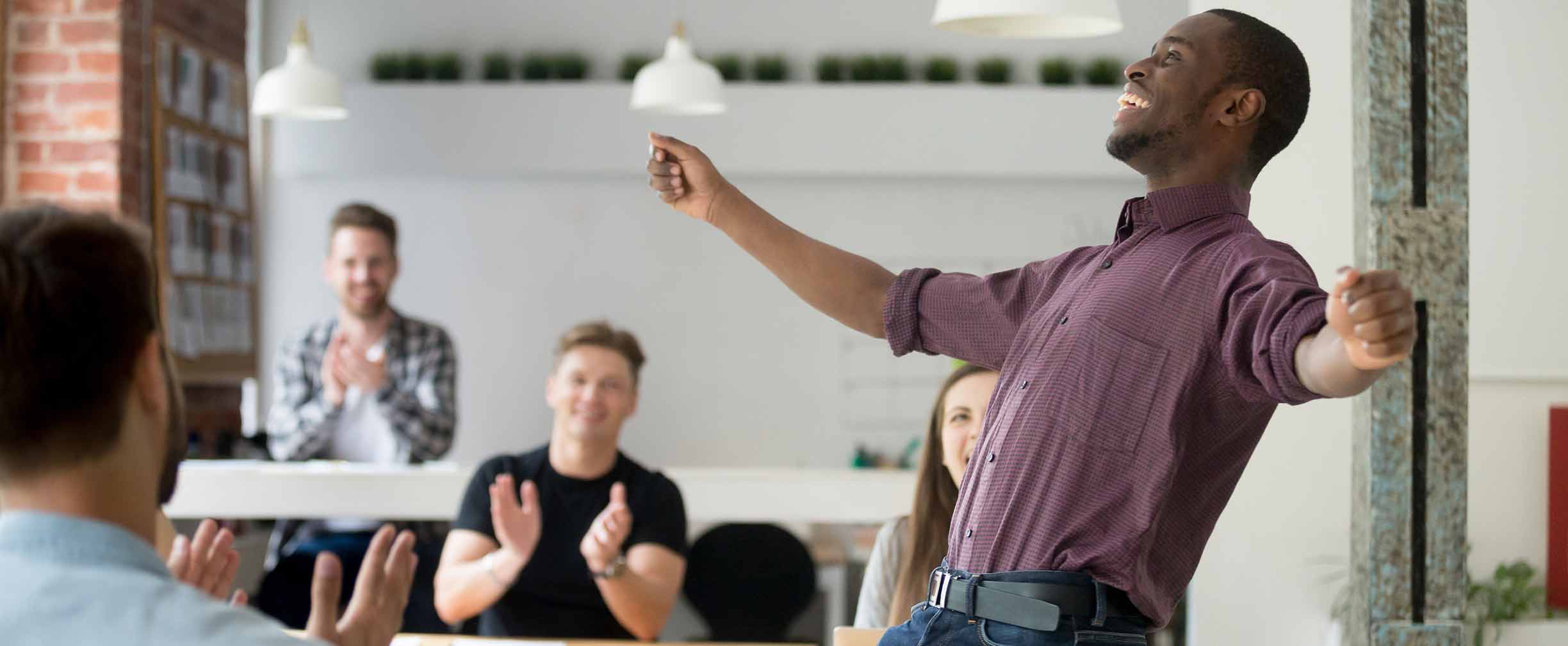 Excited man celebrating success with co-workers.