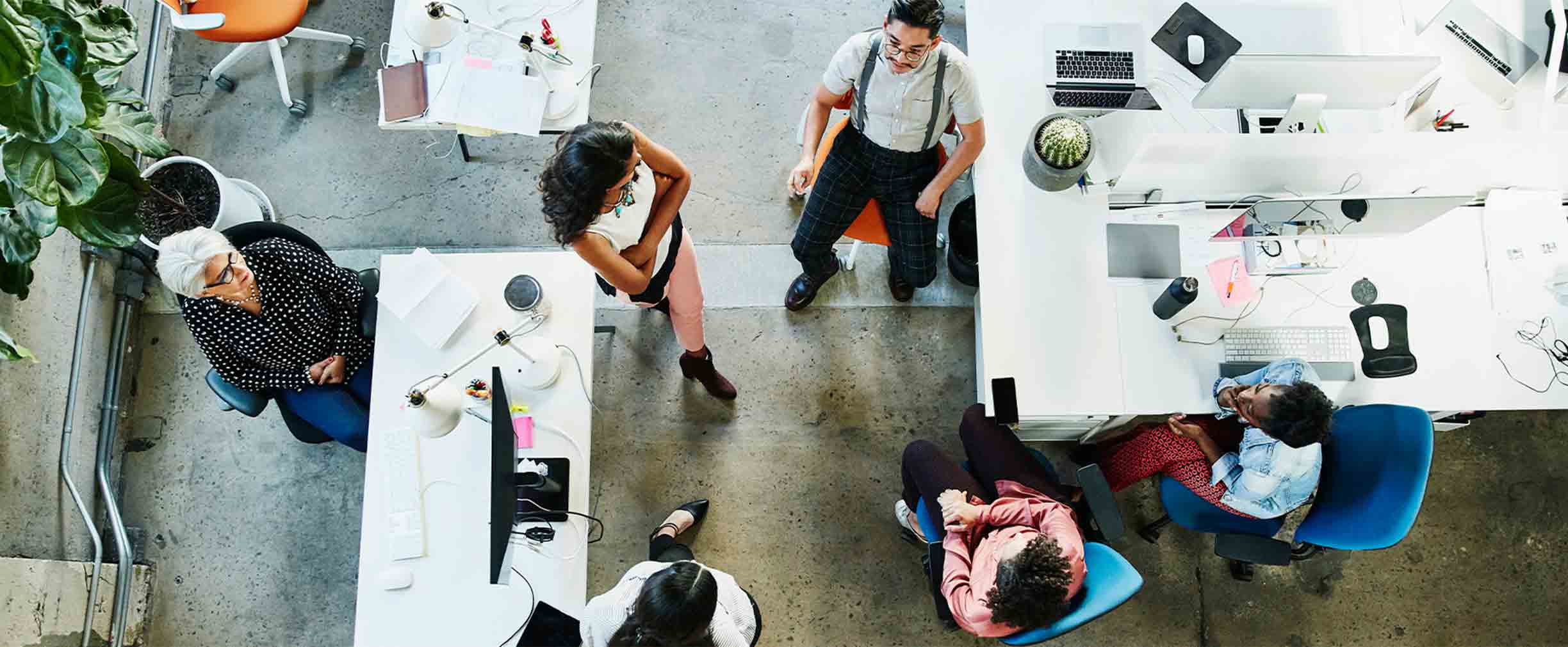 An aerial view of a diverse group of workers meeting in a startup environment.