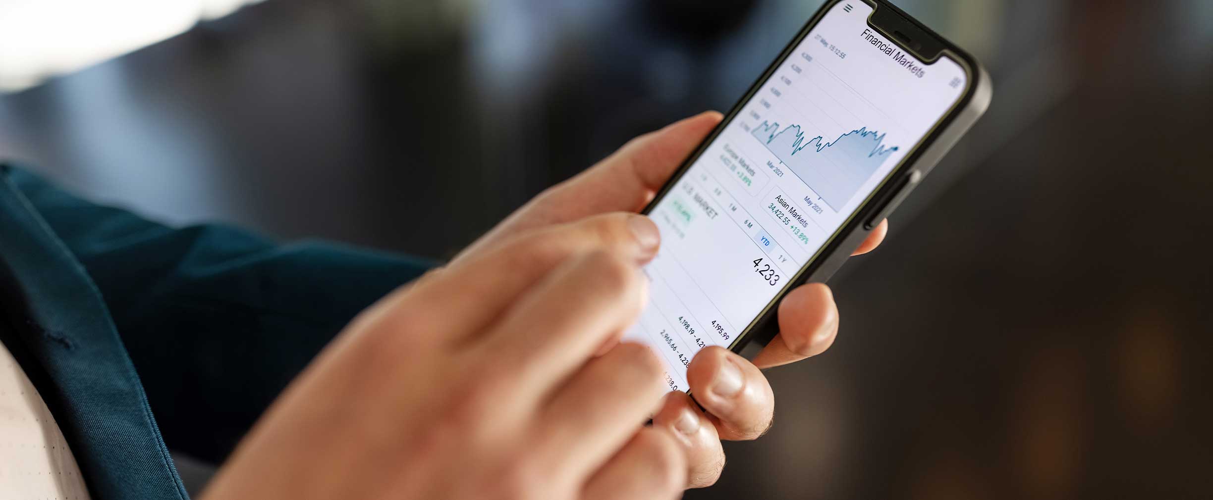 A person checking the financial market on their phone.