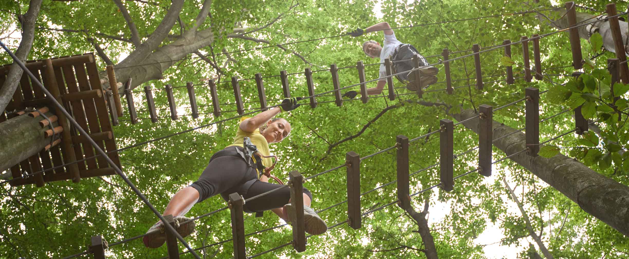 walking across a ropes course with a safety net