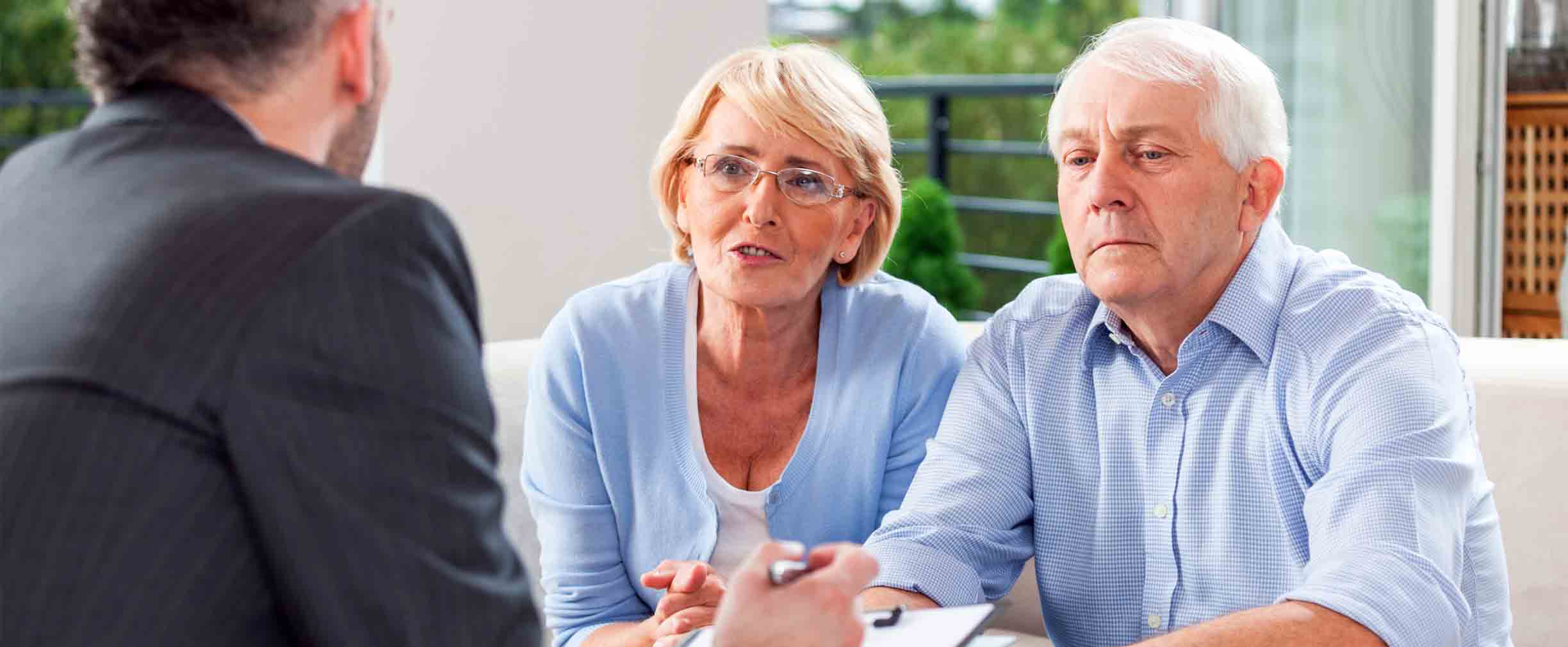 una pareja discutiendo estrategias de retiro al momento de la jubilación con un asesor financiero