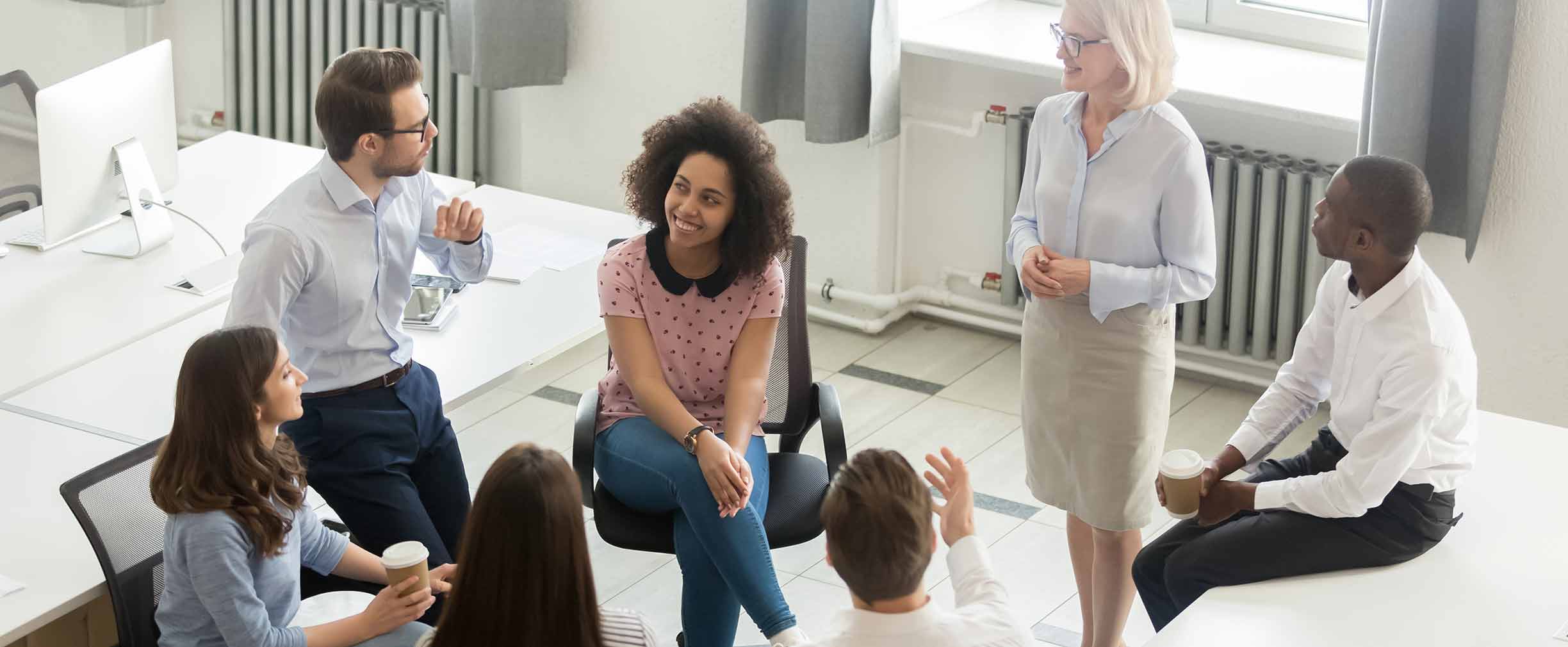 Discusión grupal, empleados hablando en círculo.