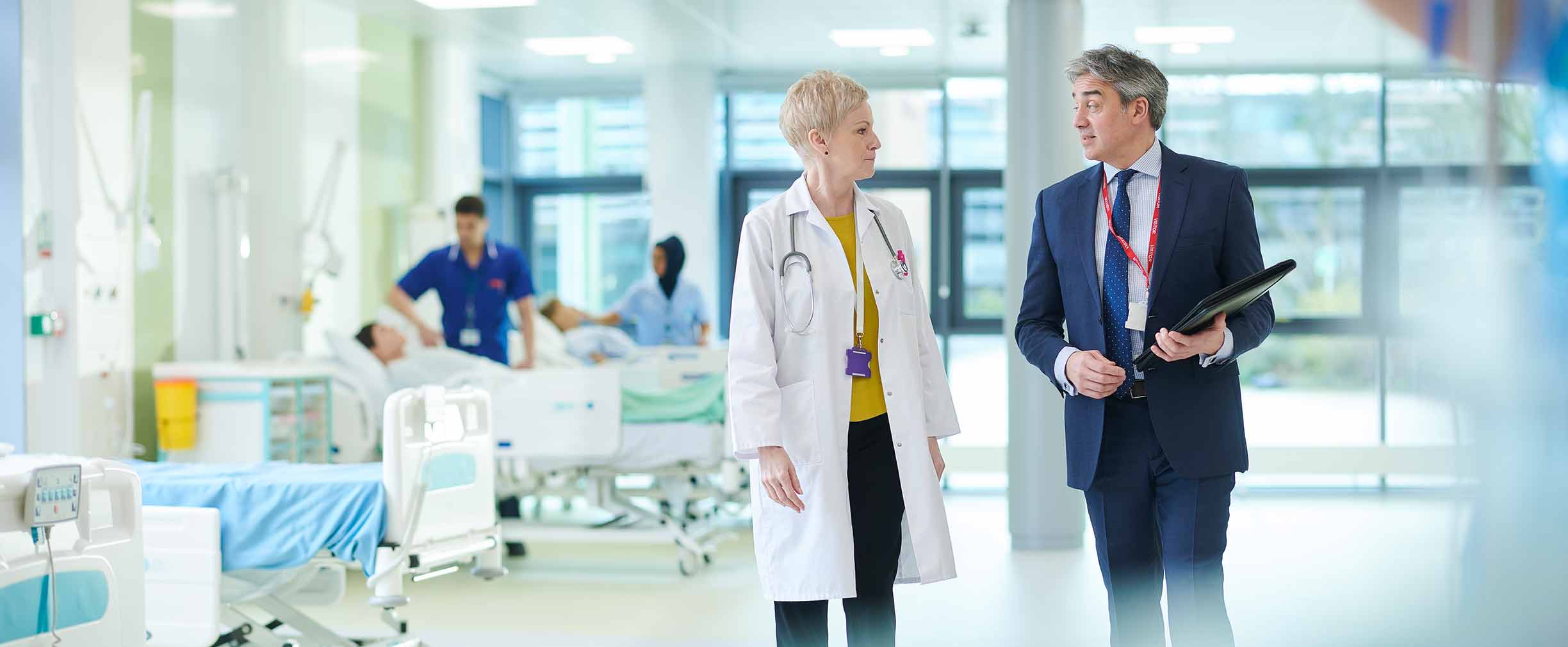 Meeting between pharma rep and senior female doctor.