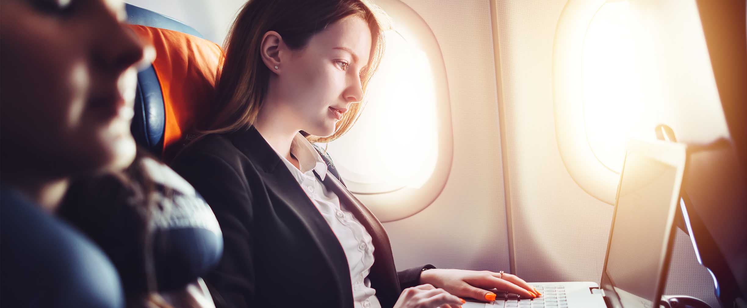 business traveler working on laptop during flight