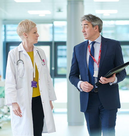 Reunión entre representante farmacéutico y médica sénior.