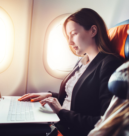 business traveler working on laptop during flight