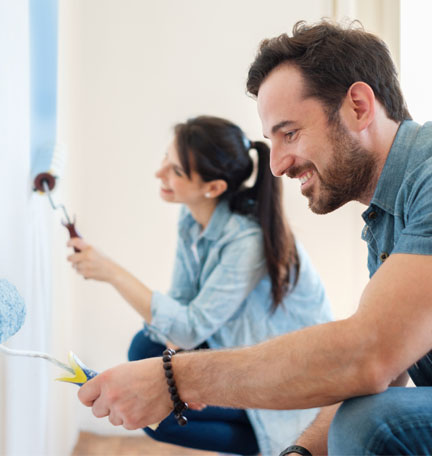 young couple painting the walls of their home
