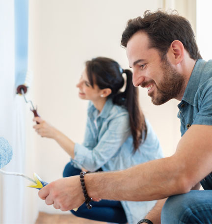 pareja joven pintando las paredes de su casa