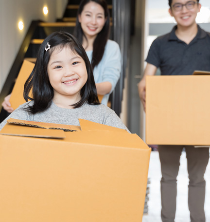 family carrying moving boxes