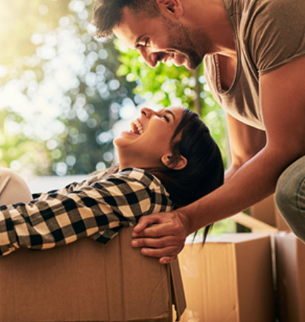 happy young couple unpacking boxes in their new home
