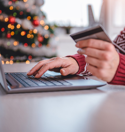 woman with credit card in hand shopping online during holidays