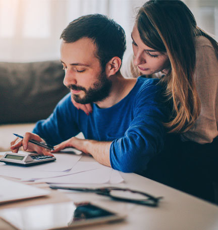 Pareja sentada en su sala de estar revisando sus finanzas