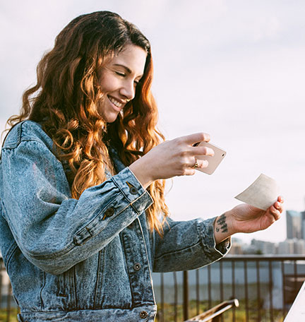 woman using mobile banking to deposit a check with her smartphone