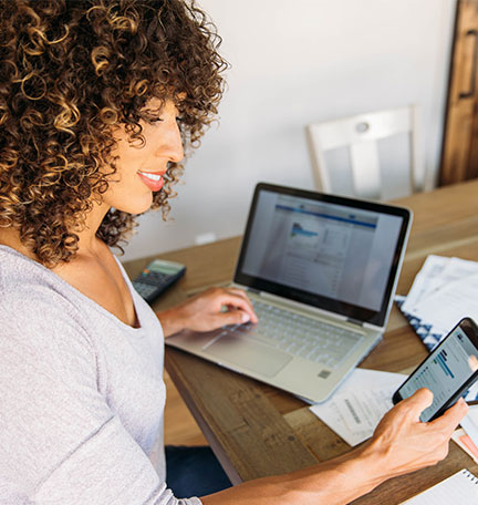 Woman Doing Finances at Home on Smart Phone stock photo