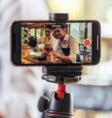 Dos baristas filmando contenido con un iPhone.