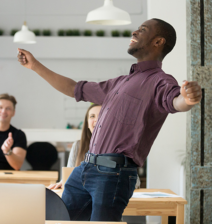 Excited man celebrating success with co-workers.
