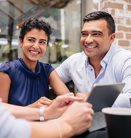 Smiling couple talking around table.