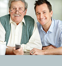 Father and son sitting at desk helping out adult kids