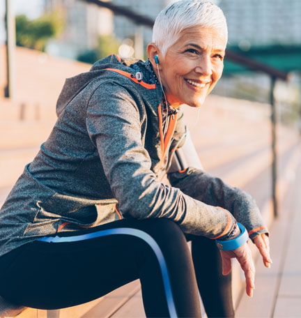 female senior sitting on a bench after a run