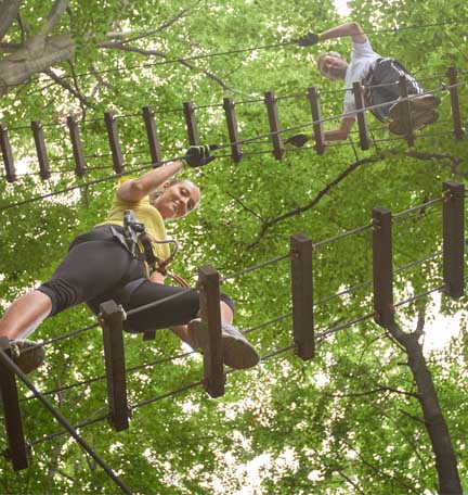 walking across a ropes course with a safety net